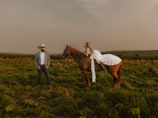 Man and woman in a field with a horse during sunset | Texanna Belles Jewelry